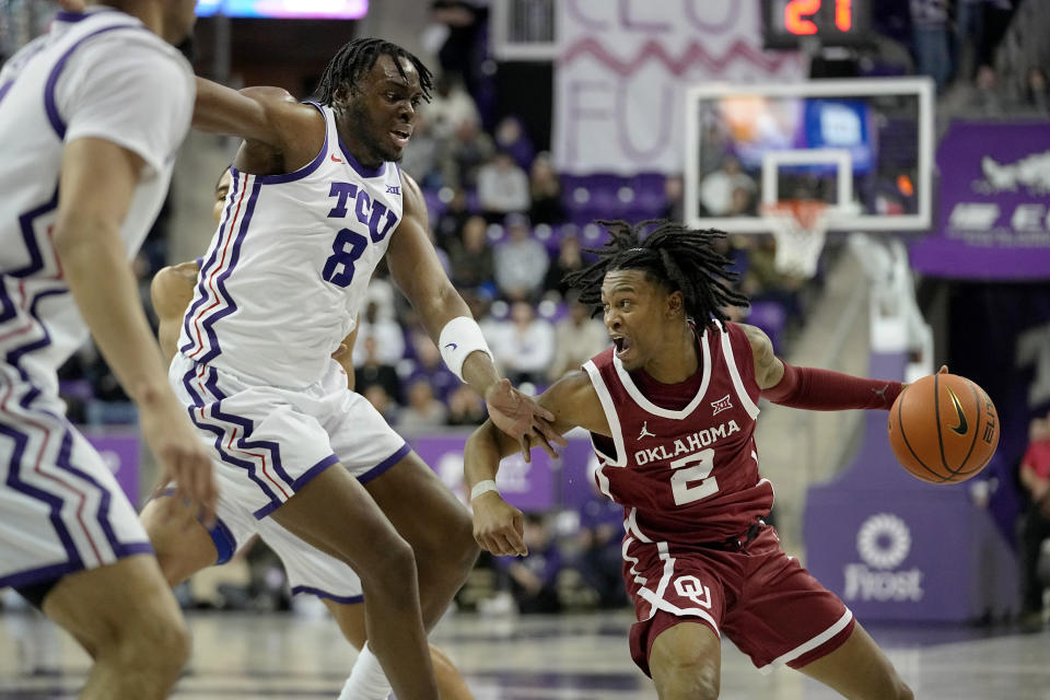 Oklahoma guard Javian McCollum (2) looks for an opening against TCU center Ernest Udeh Jr. (8) and other defenders during the first half of an NCAA college basketball game in Fort Worth, Texas, Wednesday, Jan. 10, 2024. (AP Photo/LM Otero)