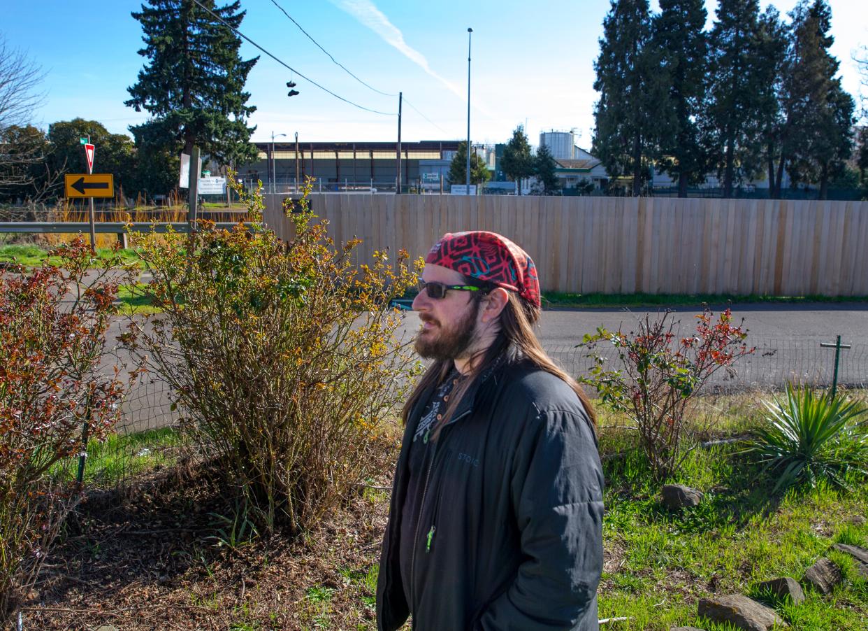 Kyle Meyer stands in his front yard near the J.H. Baxter & Co. plant that shut down in 2022 after contaminants were identified in the surrounding neighborhood linked to the Eugene wood treatment facility.