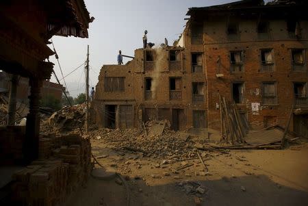 People work on top of the collapsed house to salvage belongings after the April 25 earthquake at Bhaktapur May 7, 2015. REUTERS/Navesh Chitrakar