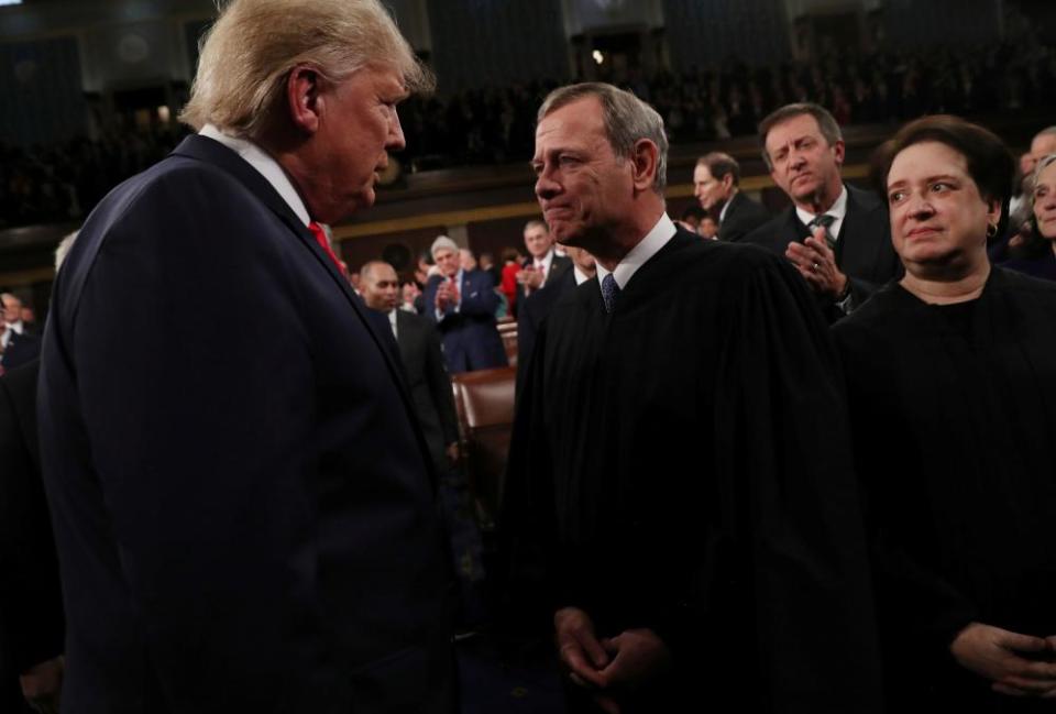 Donald Trump talks to Chief Justice John Roberts while Justice Elena Kagan looks on, in February last year.