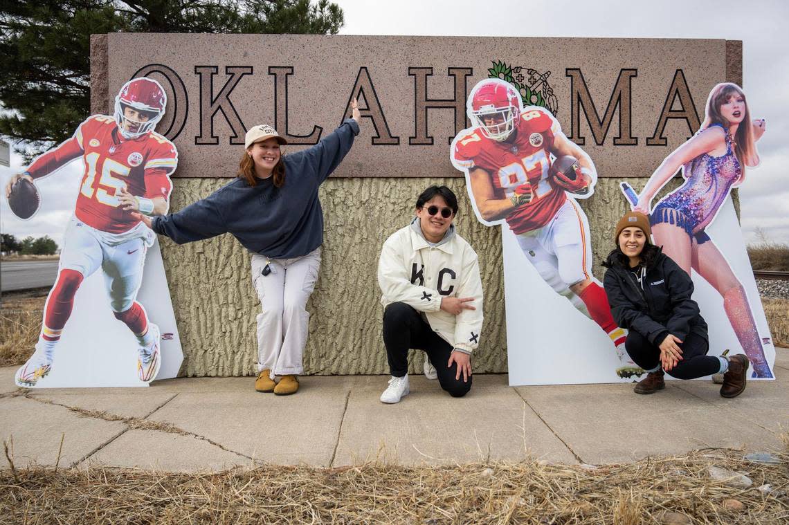 Journalists Alison Booth, left, Irvin Zhang and Emily Curiel pose for a photo in front of an Oklahoma welcome sign.