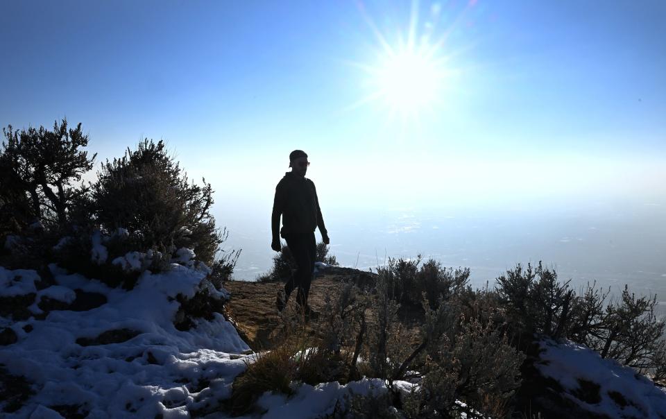 A hiker walks along the trail on Ensign Peak as an inversion thickens along the Wasatch Front on Tuesday, Nov. 28, 2023. | Scott G Winterton, Deseret News