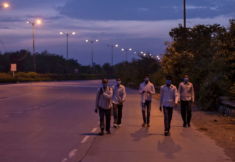 Migrant workers walk along a road to return to their villages, during a 21-day nationwide lockdown to limit the spreading of coronavirus disease, in New Delhi