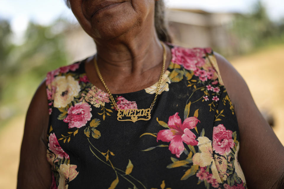 Emelda Fernandes wears a personalized name gold necklace, in Chinese Landing, Guyana, Monday, April 17, 2023. Fernandes, 66, who mined for gold at age 12, now farms peppers and cassava to survive. (AP Photo/Matias Delacroix)