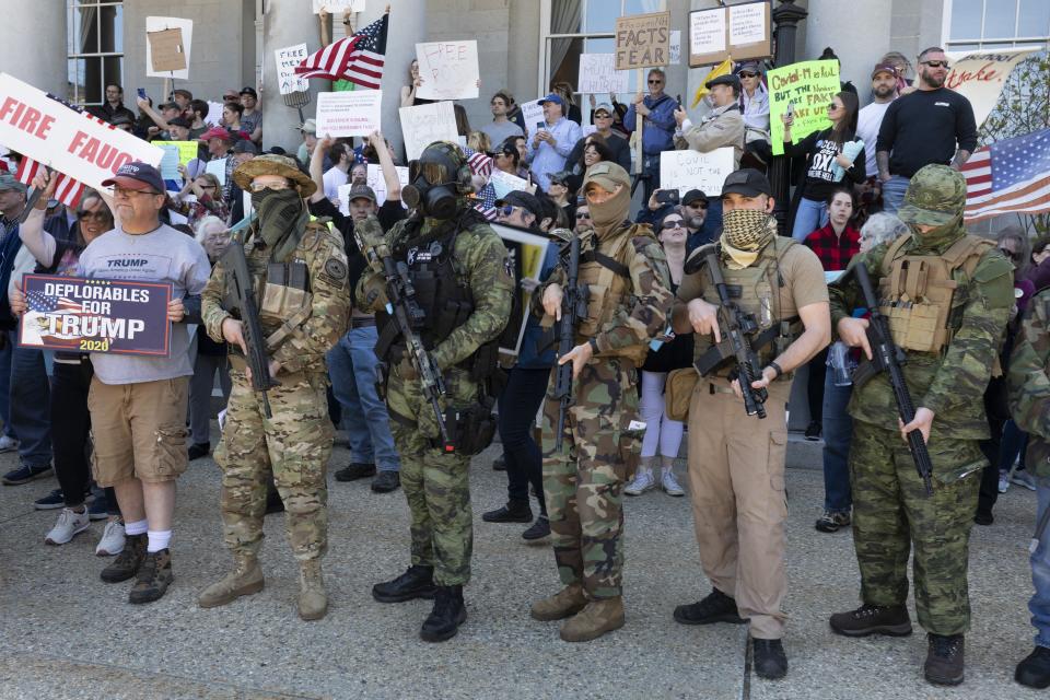 FILE - In this May 2, 2020, file photo, people, including those with the boogaloo movement, demonstrate against business closures due to concern about COVID-19, at the State House in Concord, N.H. It's a fringe movement with roots in a online meme culture steeped in irony and dark humor. But experts warn that the anti-government boogaloo movement has attracted a dangerous element of far-right extremists. (AP Photo/Michael Dwyer, File)