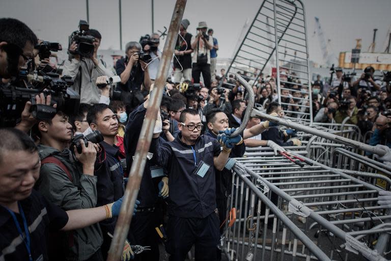 Security staff remove a barricade outside the CITIC Tower building near a pro-democracy protest site in the Admiralty district of Hong Kong, on November 18, 2014