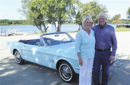 Gail (L) and Tom Wise pose with her Skylight Blue 1964 1/2 Ford Mustang convertible in Chicago, Illinois August 13, 2013. Gail Wise, then using her maiden name of Gail Brown, made the first known retail purchase of a Mustang on April 15, 1964, two days before the model went on sale. Ford will unveil its next-generation 2015 Mustang on December 5 for the model's 50th anniversary with simultaneous events in Michigan, Shanghai, Sydney, Barcelona, New York and Los Angeles. REUTERS/Courtesy of Tom and Gail Wise/Handout via Reuters