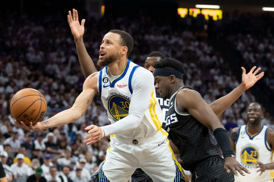 Golden State Warriors guard Stephen Curry drives past Sacramento Kings forward Harrison Barnes (40) and guard Terence Davis (3) during Game 7 of their first-round series.