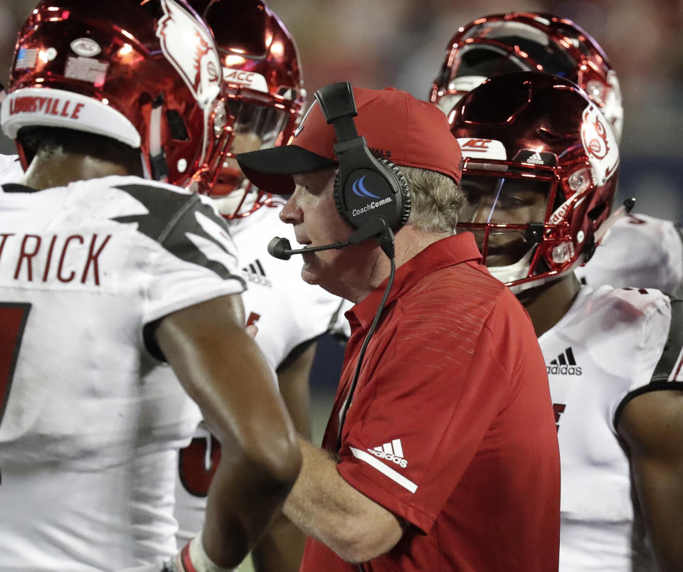 Louisville coach Bobby Petrino talks to his players during a timeout in the first half of an NCAA college football game against Alabama, Saturday, Sept. 1, 2018, in Orlando, Fla. (AP Photo/John Raoux)