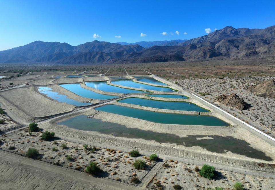 Mountains are reflected in aquifer recharge ponds.