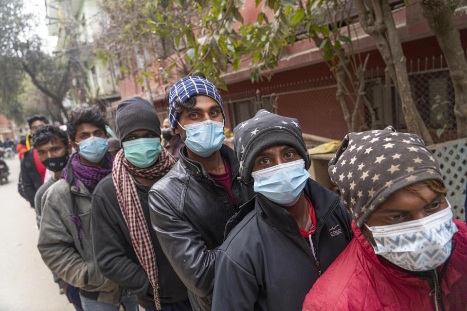 People stand in a queue to receive the vaccine after the Nepalese government made vaccination cards mandatory for people to access public services in Kathmandu, Nepal, Thursday, Jan. 20, 2022. (AP Photo/Niranjan Shrestha)