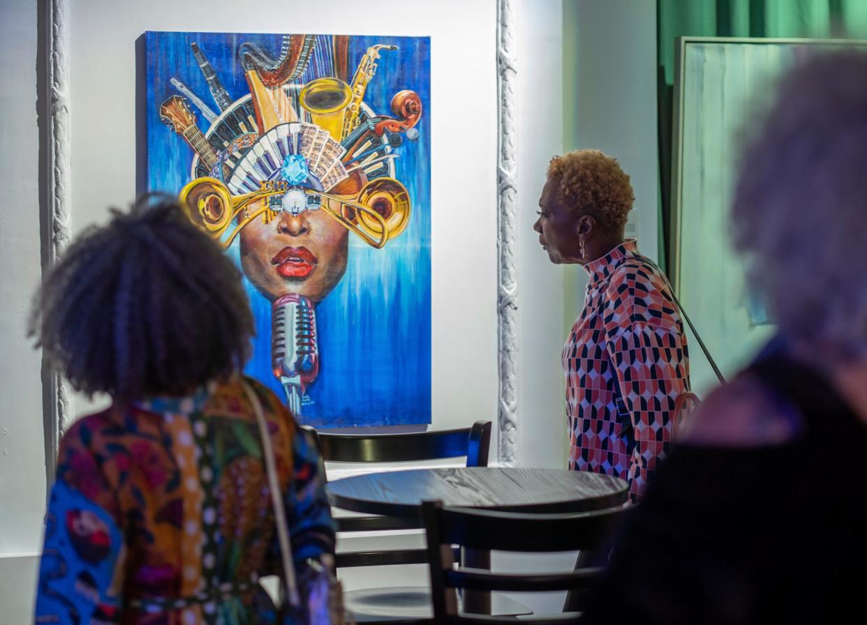 Grammy nominated jazz singer and artist Carmen Lundy, right, of Los Angeles, looks over an acrylic painting by artist Carla Harden during a VIP event at the Carr Center Performance Studio in Detroit on Thursday, Oct. 13, 2022.
(Credit: Ryan Garza, Detroit Free Press)