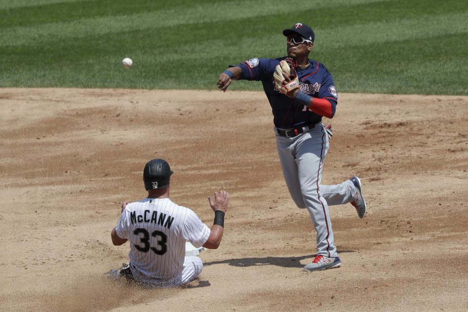 Minnesota Twins shortstop Jorge Polanco, right, throws to first after forcing out Chicago White Sox's James McCann at second during the third inning of a baseball game in Chicago, Saturday, July 25, 2020. Chicago White Sox's Leury Garcia was safe at first. (AP Photo/Nam Y. Huh)