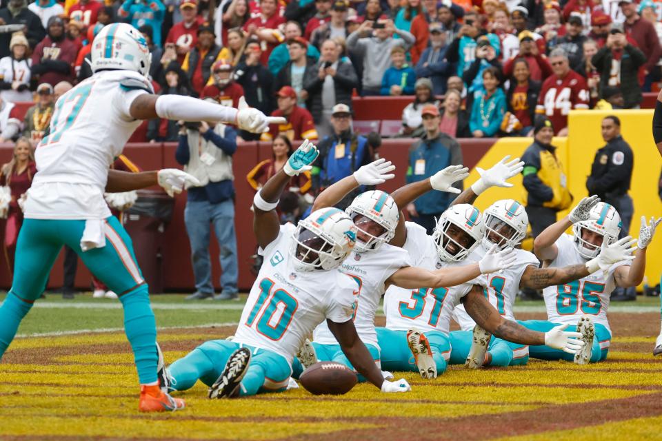 Dec 3, 2023; Landover, Maryland, USA; Miami Dolphins wide receiver Tyreek Hill (10) celebrates in the end zone after catching a touchdown pass against the Washington Commanders during the first quarter at FedExField. Mandatory Credit: Geoff Burke-USA TODAY Sports