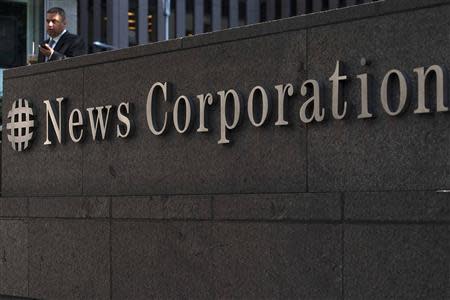 A passer-by stands in front of the News Corporation building in New York in this June 28, 2012 file photo. REUTERS/Keith Bedford/Files