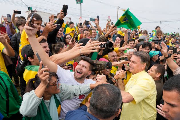 Jair Bolsonaro, wearing yellow, has sought to mobilize his supporters in the hopes that they will help him cast doubt on the results of Sunday's election, especially if he loses outright in the first round of voting. (Photo: (AP Photo/Andre Penner))