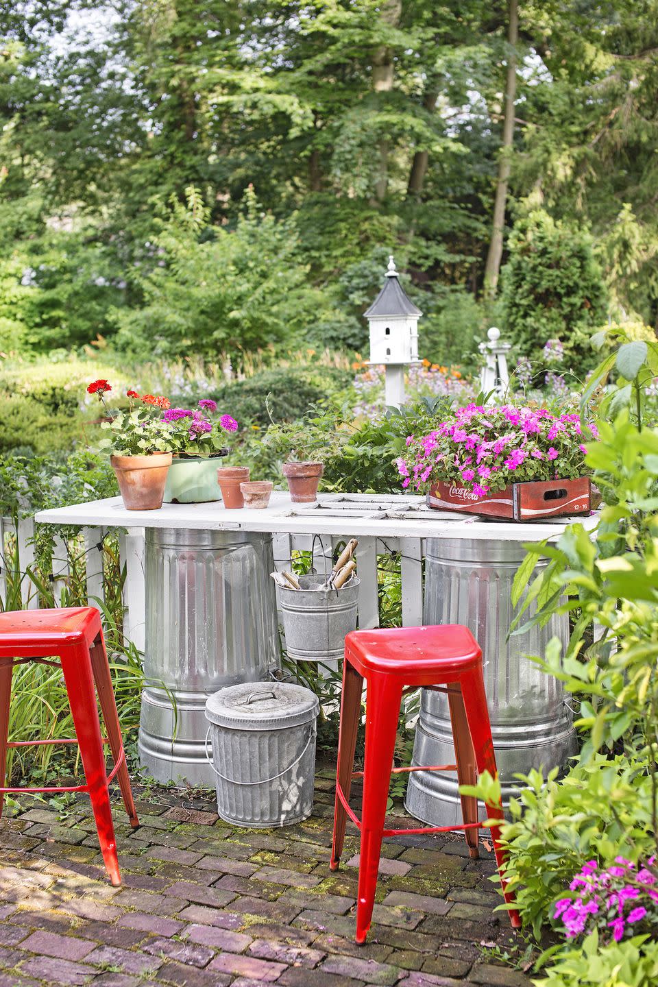 <p>Take upcycling to the next level: For a budget-friendly work bench, attach an old door or piece of wood to two waist-height metal pails or garbage cans. Place it near your garden, so you can keep your eye on your bounty as you work your magic. </p>