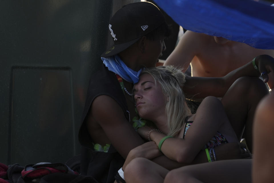 People waiting for the start of a vigil with Pope Francis, ahead of the 37th World Youth Day, rest in the shade at the Parque Tejo in Lisbon, Saturday, Aug. 5, 2023. On Sunday morning, the last day of his five-day trip to Portugal, Francis is to preside over a final, outdoor Mass on World Youth Day – when temperatures in Lisbon are expected to top 40 degrees C (104F) – before returning to the Vatican. (AP Photo/Ana Brigida)