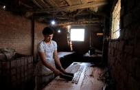 Mohamed Abdul Rahman, 18, compresses sliced papyrus plant at a workshop in al-Qaramous village