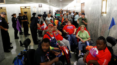 Protesters, mostly handicapped, line the hallway outside the Senate Finance Committee hearing room hours ahead a hearing on the latest Republican effort to repeal Obamacare on Capitol Hill in Washington, U.S., September 25, 2017. REUTERS/Kevin Lamarque