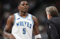 Minnesota Timberwolves guard Anthony Edwards, left, confers with head coach Chris Finch in the first half of an NBA basketball game against the Denver Nuggets Friday, March 29, 2024, in Denver. (AP Photo/David Zalubowski)