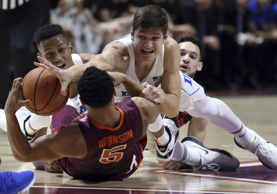 Duke’s Grayson Allen (3) reaches for the ball on top of Virginia Tech’s Justin Robinson (5) during the first half of an NCAA college basketball game Monday, Feb. 26, 2018, in Blacksburg, Va. (Matt Gentry/The Roanoke Times via AP)