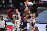 Minnesota Timberwolves center Karl-Anthony Towns (32) loses the ball against Washington Wizards forward Davis Bertans (42) and forward Deni Avdija, right, during the first half of an NBA basketball game, Saturday, Feb. 27, 2021, in Washington. (AP Photo/Nick Wass)