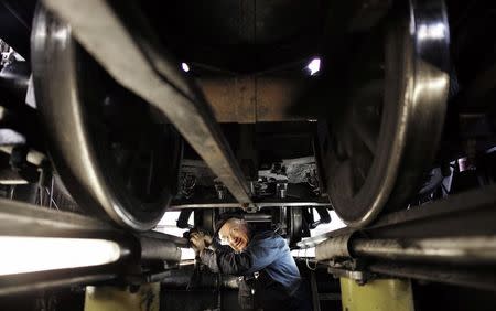 Puffing Billy steam engine driver Steve Holmes, 61, checks the running gear in the inspection pit under locomotive 6A at Belgrave near Melbourne, October 17, 2014. REUTERS/Jason Reed