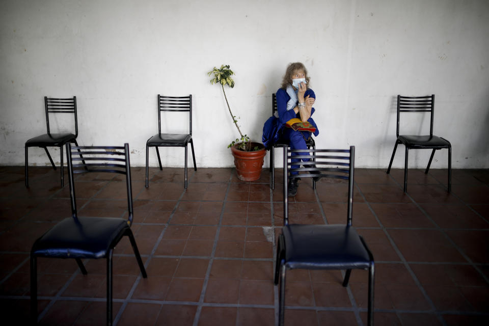 Carmela Corleto sits during an observation period after getting her first shot of the AstraZeneca vaccine for COVID-19 at a vaccination center in Almirante Brown, Argentina, Friday, April 23, 2021. (AP Photo/Natacha Pisarenko)