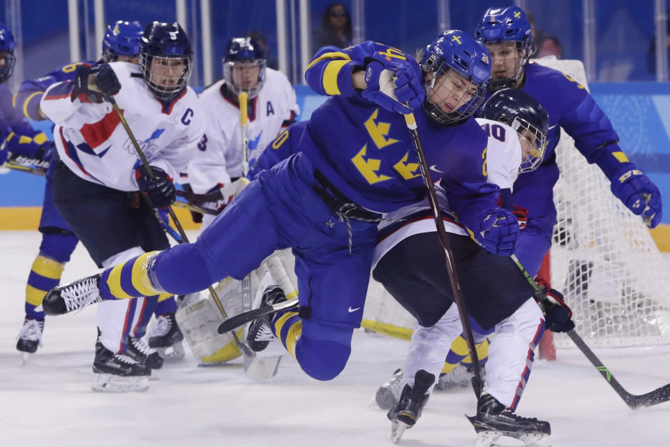 FILE - In this Feb. 20, 2018, file photo, Erika Grahm (24), of Sweden, fights for control of the puck with South Korea's Choi Jiyeon (10), of the combined Koreas team, during the first period of the classification round of the women's hockey game at the 2018 Winter Olympics in Gangneung, South Korea. The leading female hockey players in Sweden were refusing to attend a training camp Thursday, Aug. 15, 2019, or play in an upcoming international tournament in Finland over a pay dispute with the country’s federation. A statement was posted on social media by Sweden player Erika Grahm, saying the action is being taken to “develop and create better conditions” in the national team to show “encouragement and respect” for current and future generations.(AP Photo/Frank Franklin II, File)