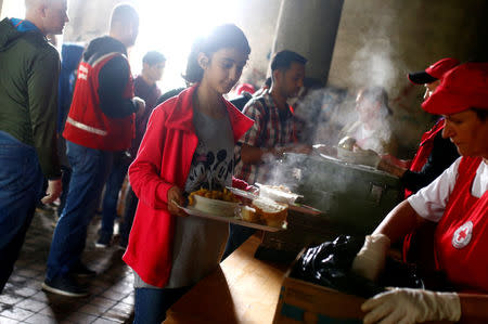 Migrants wait for food inside a dorm destroyed during the Bosinian 1992-1995 war, in Bihac, Bosnia and Herzegovina May 11, 2018. REUTERS/Dado Ruvic