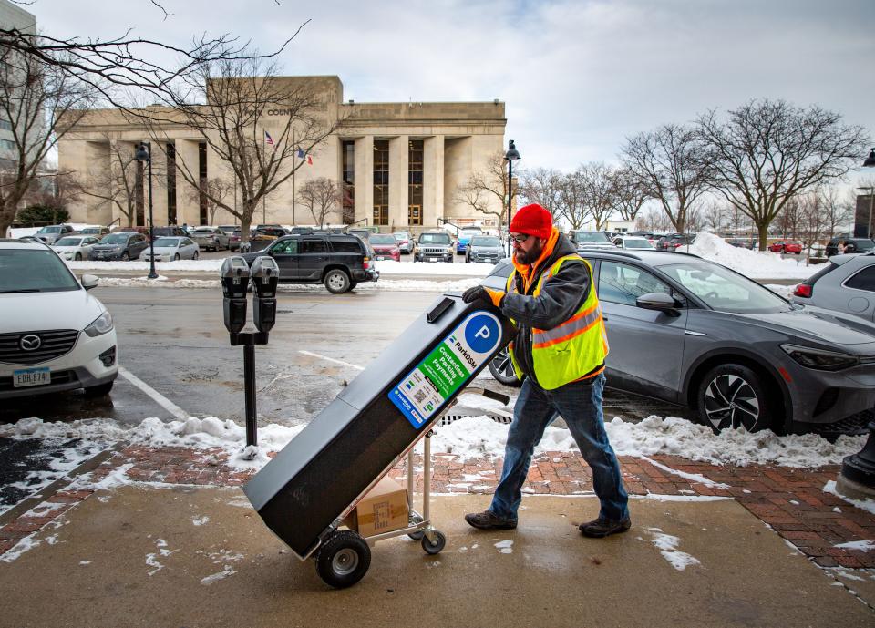 Craig Knutson with the Baker Group installs new parking payment boxes on Court Ave. in Des Moines, Tuesday, Jan. 4, 2022.