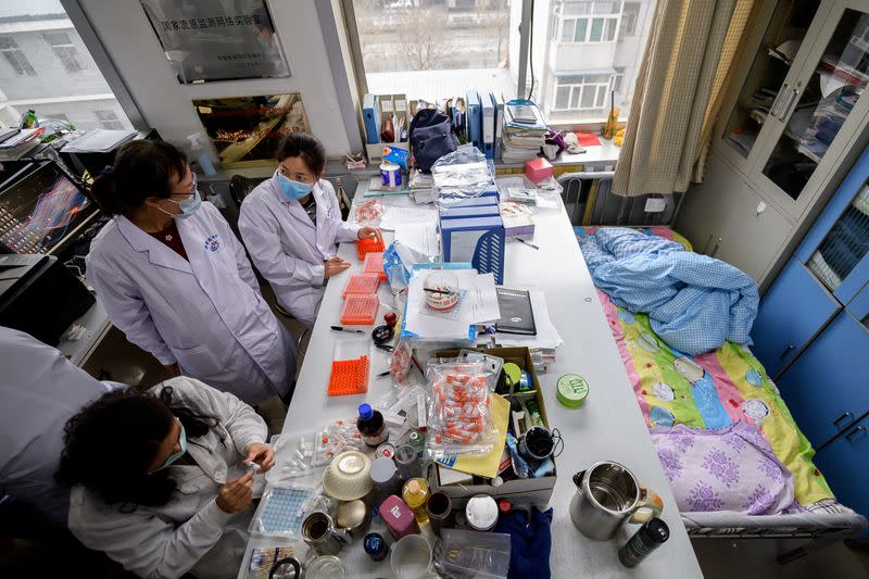 Workers are seen next to a bed placed inside an office at a centre for disease control and prevention, as the country is hit by an outbreak of the novel coronavirus, in Taiyuan