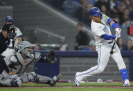 Toronto Blue Jays' Justin Turner (2) hits a single next to New York Yankees catcher Jose Trevino during the fifth inning of a baseball game Tuesday, April 16, 2024, in Toronto. (Nathan Denette/The Canadian Press via AP)