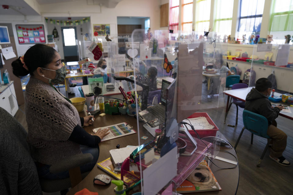 FILE - In this March 18, 2021, file photo, surrounded by protective shields, pre-kindergarten teacher Tami Lewis teaches her class at West Orange Elementary School in Orange, Calif. With a massive infusion of federal aid coming their way, schools across the U.S. are weighing how to use the windfall to ease the harm of the pandemic — and to tackle problems that existed long before the coronavirus. (AP Photo/Jae C. Hong, File)