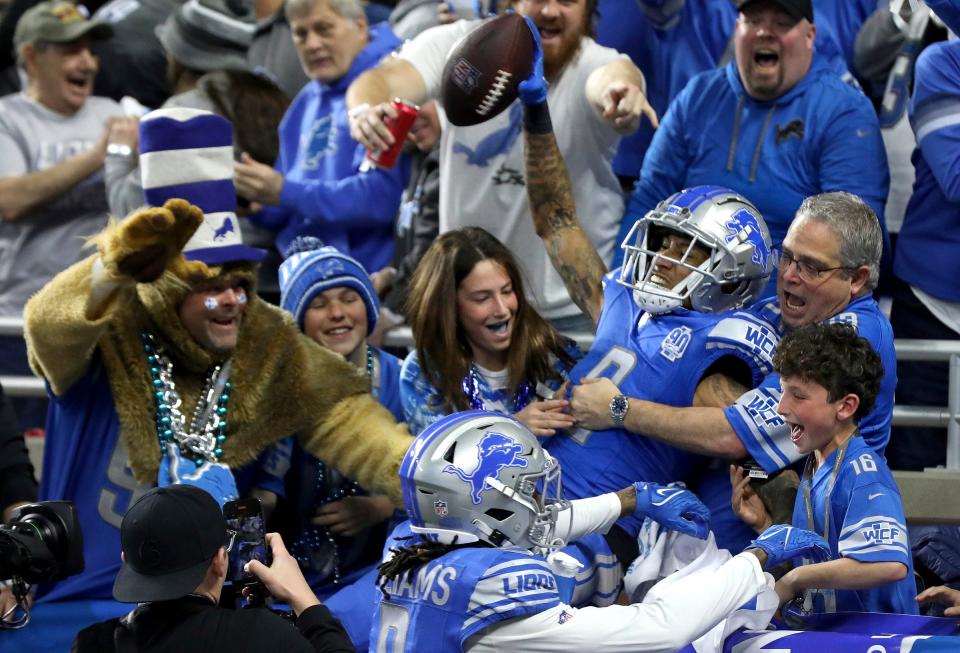 Detroit Lions wide receiver Josh Reynolds celebrates with fans after scoring a touchdown against the Tampa Bay Buccaneers in the divisional playoffs.
