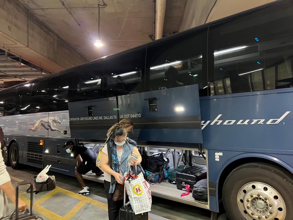 Bus passengers storing their luggages in a Greyhound coach bus.