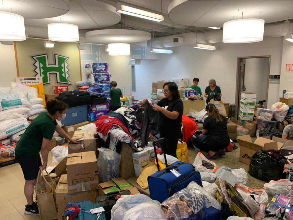 University of Hawai'i athletic department staff and volunteers sort through donations being sent to Maui residents.