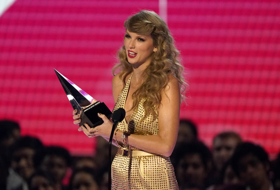 FILE - Taylor Swift accepts the award for favorite pop album for "Red (Taylor's Version)" at the American Music Awards on Nov. 20, 2022, at the Microsoft Theater in Los Angeles. Swift’s signed acoustic guitar, Eminem’s signed tennis shoes and an ensemble worn by a BTS member are among the items up for bid during a Grammy-week auction on Feb. 5, 2023, Julien’s Auctions said Tuesday, Jan. 17. (AP Photo/Chris Pizzello, File)