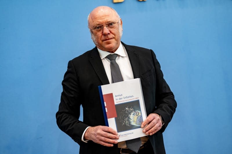 Chief Executive of the Joint overall association "Paritatischer Gesamtverband" Ulrich Schneider holds up the report on poverty trends during the Federal Press Conference under the motto "Poverty in Inflation" of the Joint overall association. Fabian Sommer/dpa