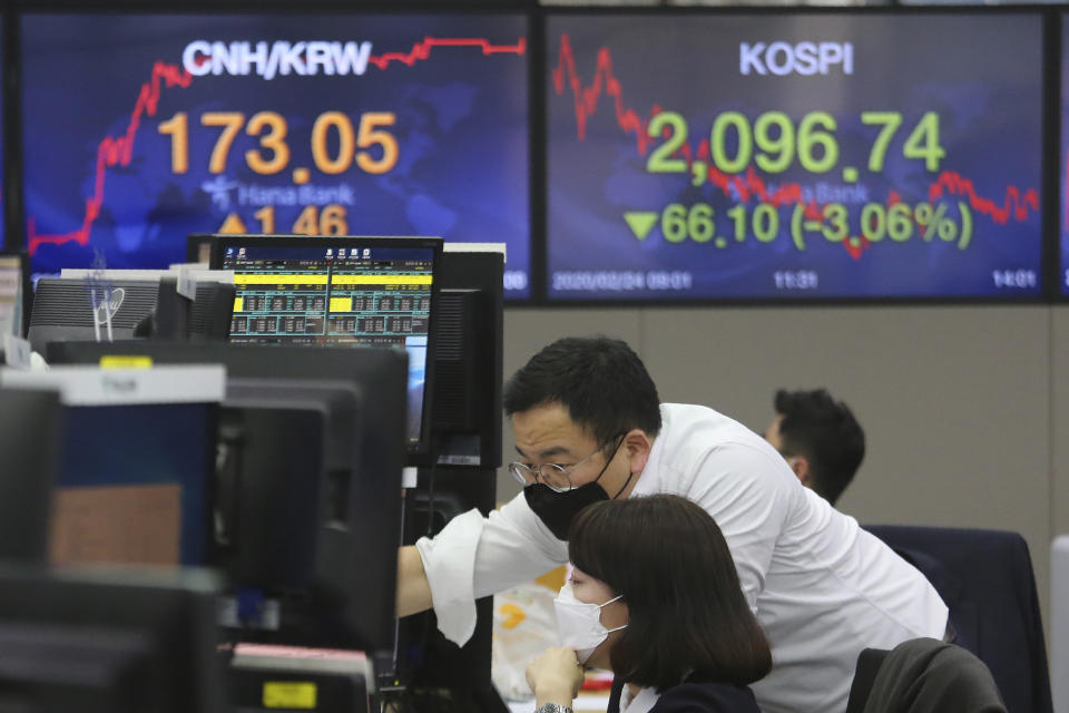 Currency traders wear face masks as they watch monitors at the foreign exchange dealing room of the KEB Hana Bank headquarters in Seoul, South Korea, Monday, Feb. 24, 2020.(AP Photo/Ahn Young-joon)