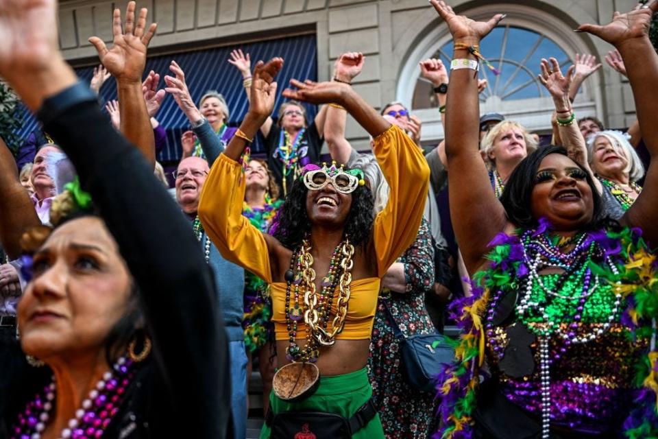 Revellers catch beads from a float in the 2023 Zulu Social Aid and Pleasure Club parade during a Mardi Gras celebration in New Orleans on Feb. 21, 2023.