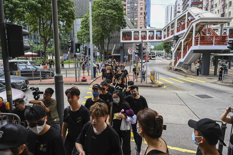 People wait outside a funeral home to pay their respects to Coco Lee in Hong Kong, Tuesday, Aug. 1, 2023. Lee was being mourned by family and friends at a private ceremony Tuesday a day after fans paid their respects at a public memorial for the Hong Kong-born entertainer who had international success. (AP Photo/Billy H.C. Kwok)