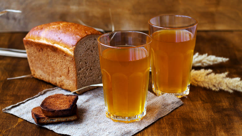 Two glasses of beer and a loaf of bread