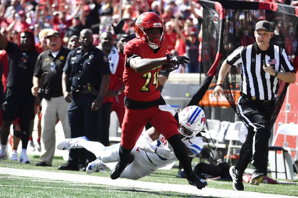 SMU cornerback Jaelyn Davis-Robinson (13) tries to bring down Louisville wide receiver Ahmari Huggins-Bruce (24) during the first half of an NCAA college football game in Louisville, Ky., Saturday, Oct. 5, 2024. (AP Photo/Timothy D. Easley)