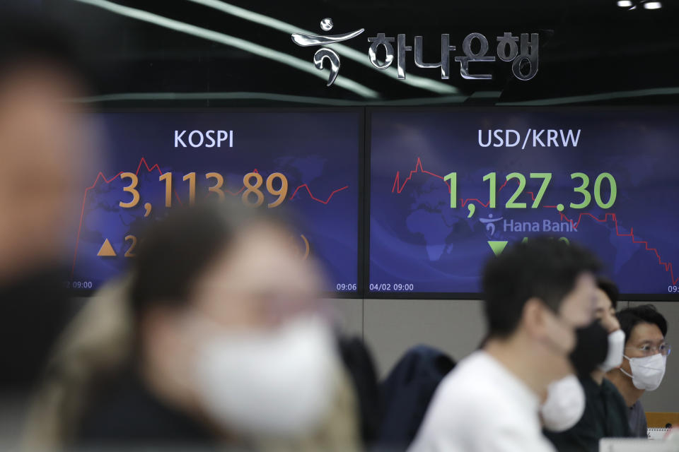 Currency traders watch computer monitors near screens showing the Korea Composite Stock Price Index (KOSPI), left, and the foreign exchange rate between U.S. dollar and South Korean won at the foreign exchange dealing room of the KEB Hana Bank headquarters in Seoul, South Korea, Friday, April 2, 2021. Asian shares were higher Friday after a broad rally pushed the S&P 500 past 4,000 points for the first time. (AP Photo/Lee Jin-man)