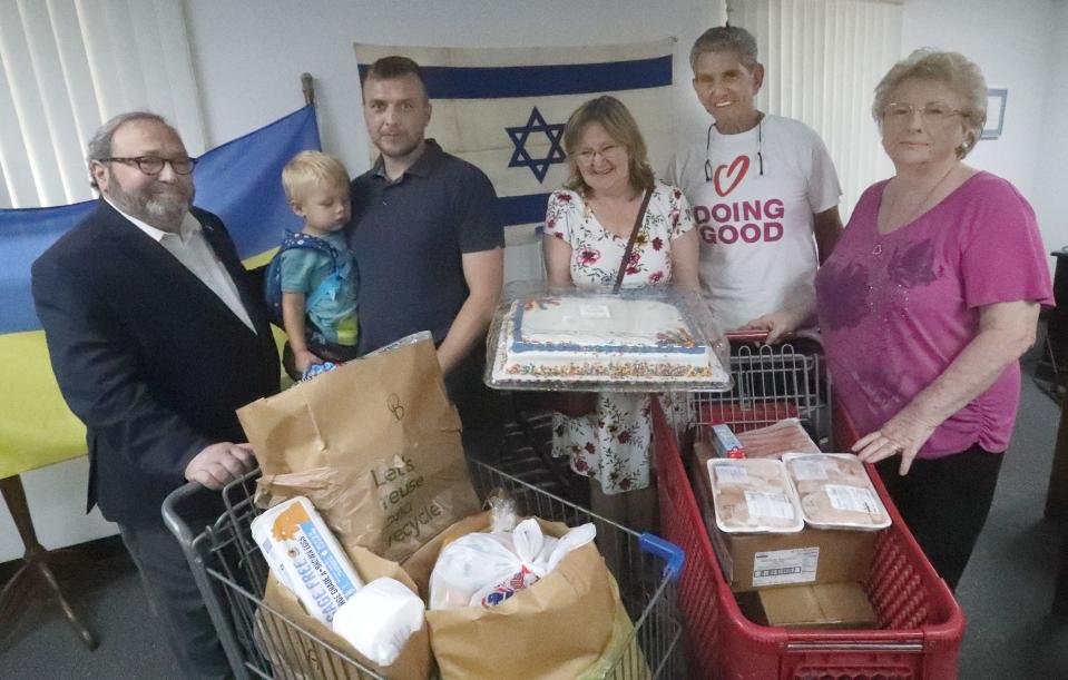 Rob Lennick, new executive director of the Jewish Federation of Volusia & Flagler Counties, at left, is pictured with Ukrainian refugee Ostap Losyk, his young son Zachar, Ostap's aunt Maria Zachar Galina Jewish Federation President Marvin Miller and executive assistant Janice Sumner at the Federation's Jerry Doliner Food Bank. Lennick replaces the Federation's longtime leader Gloria Max, who died of cancer in September 2021 at age 80.