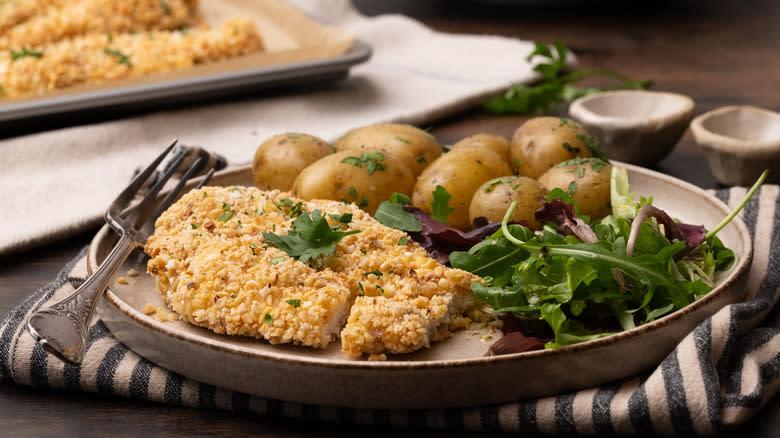 hazelnut crumb-coated chicken with salad and potatoes