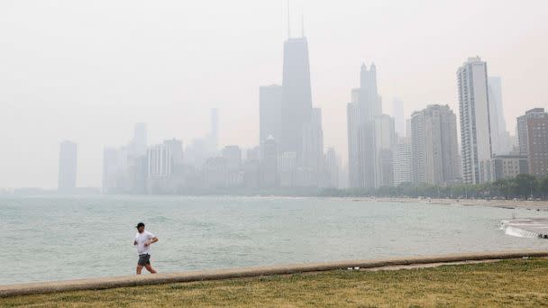 PHOTO: A jogger runs along the shoreline of Lake Michigan with heavy smoke from the Canadian wildfires, June 27, 2023, in Chicago, Illinois. (Kamil Krzaczynski/AFP via Getty Images)