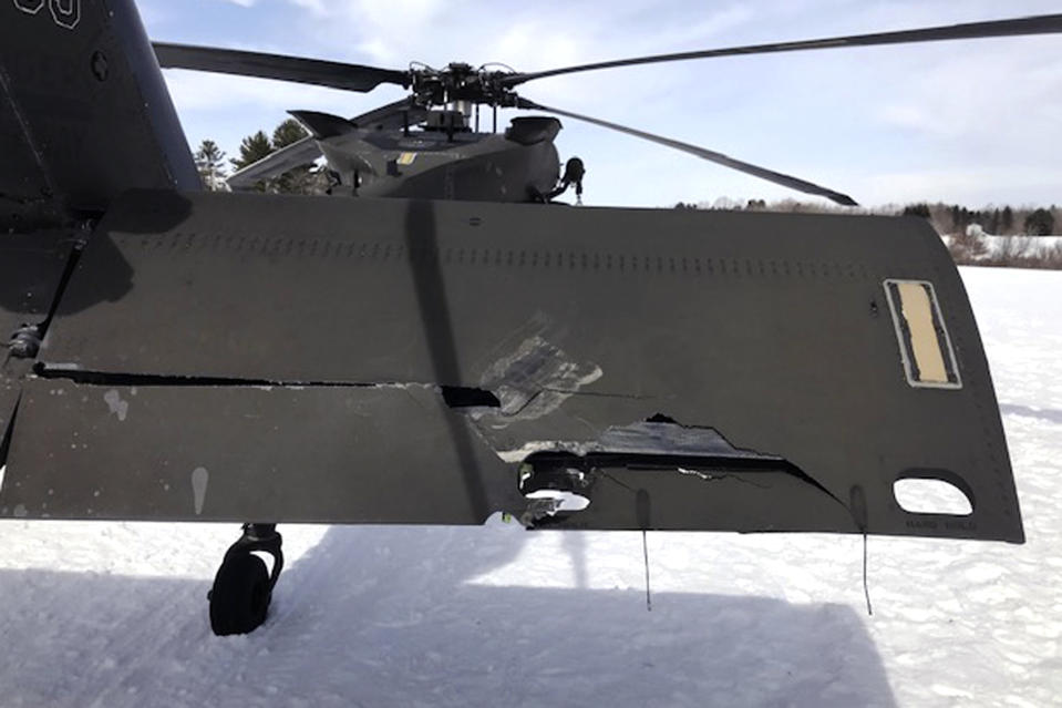 In this U.S. Army photograph by attorney Douglas Desjardins, a damaged Black Hawk helicopter rests on the snow, March 13, 2019, in Worthington, Mass. A Massachusetts man wants the government to pay nearly $10 million after being badly injured in a crash with a Black Hawk helicopter. The lawsuit filed by Jeffrey Smith against the government follows a 2019 crash in which Smith's snowmobile collided with the helicopter that was parked on a trail at dusk. (U.S. Army photograph provided by attorney Douglas Desjardins via AP)